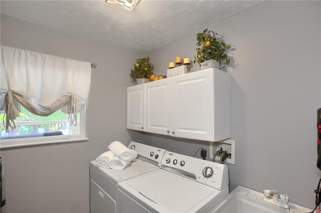 laundry area with cabinets, separate washer and dryer, and a textured ceiling