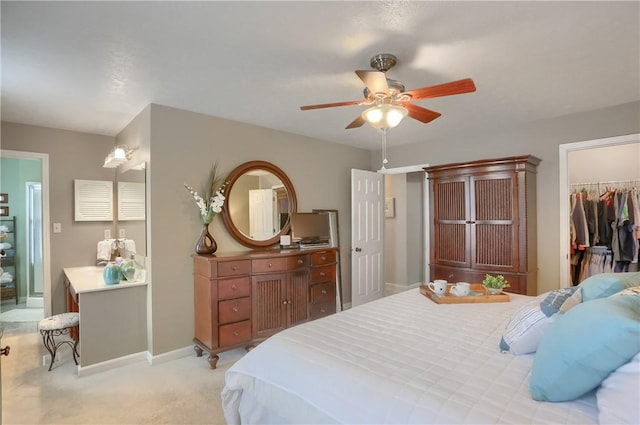 carpeted bedroom featuring ceiling fan, a spacious closet, and a closet