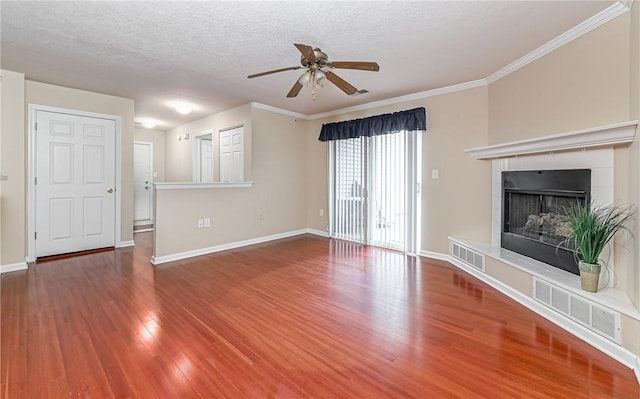 unfurnished living room featuring hardwood / wood-style flooring, ceiling fan, crown molding, and a textured ceiling