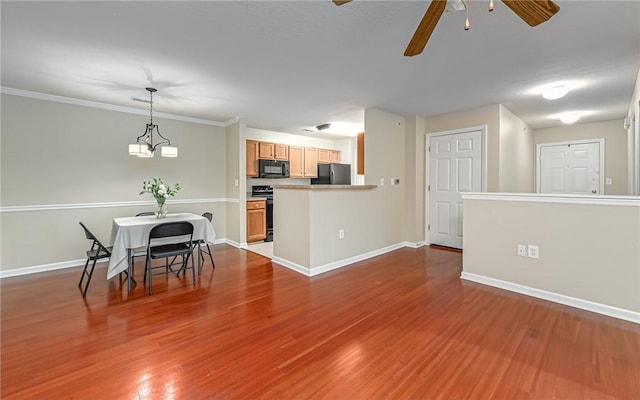 interior space with pendant lighting, hardwood / wood-style flooring, ceiling fan, black appliances, and light brown cabinetry