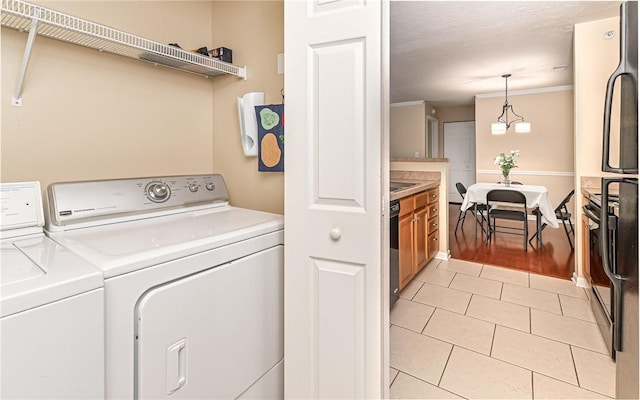 laundry area with light tile patterned floors and washing machine and clothes dryer