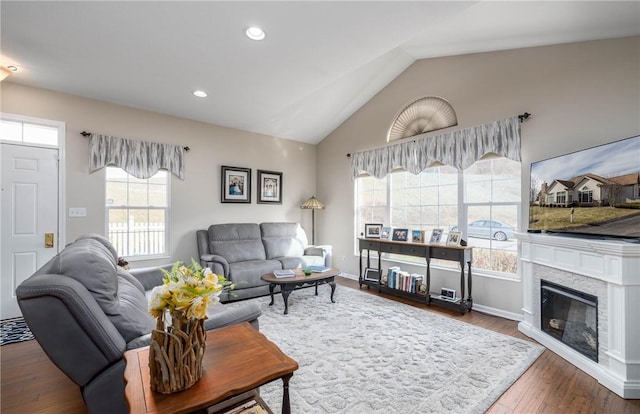 living room with dark wood-type flooring, lofted ceiling, and a healthy amount of sunlight