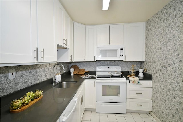 kitchen featuring sink, white cabinets, and white appliances