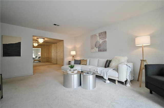 carpeted living room with a notable chandelier