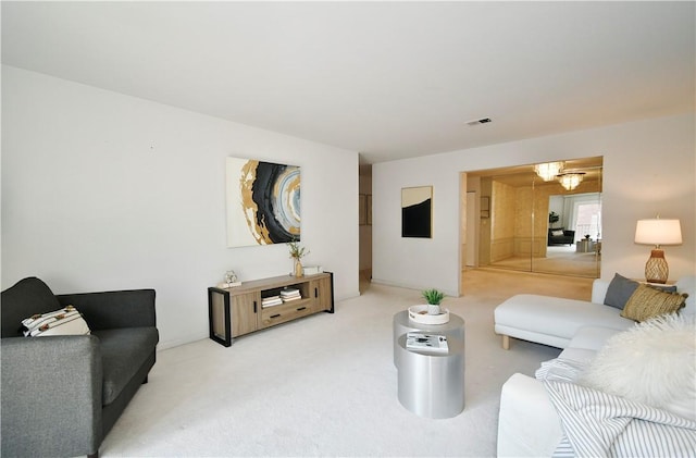 living room with an inviting chandelier and carpet floors