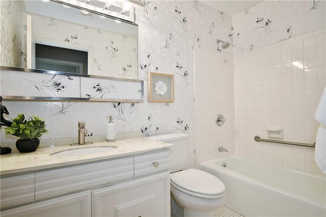 full bathroom featuring vanity, tiled shower / bath combo, and toilet