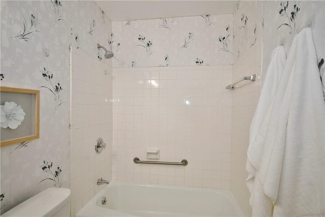 bathroom with toilet and tiled shower / bath