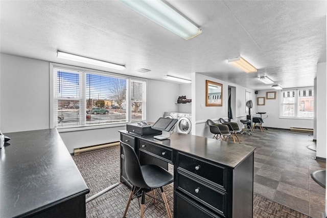 home office featuring a baseboard heating unit, washer and clothes dryer, and a textured ceiling