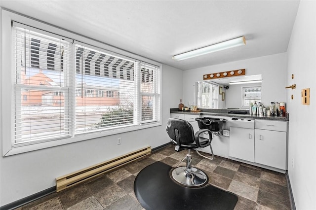 interior space featuring a baseboard radiator, dishwasher, and white cabinets