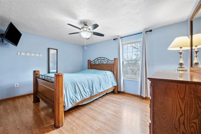 bedroom with ceiling fan, light hardwood / wood-style flooring, and a textured ceiling