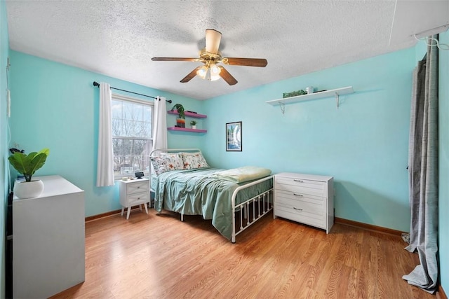 bedroom featuring ceiling fan, light hardwood / wood-style floors, and a textured ceiling