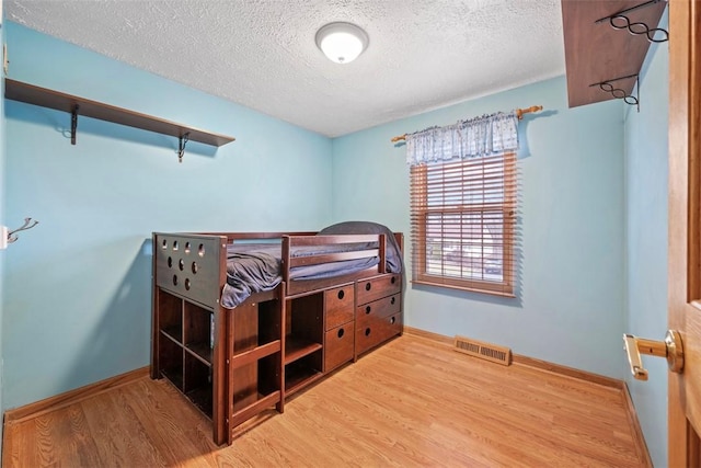 bedroom with wood-type flooring and a textured ceiling