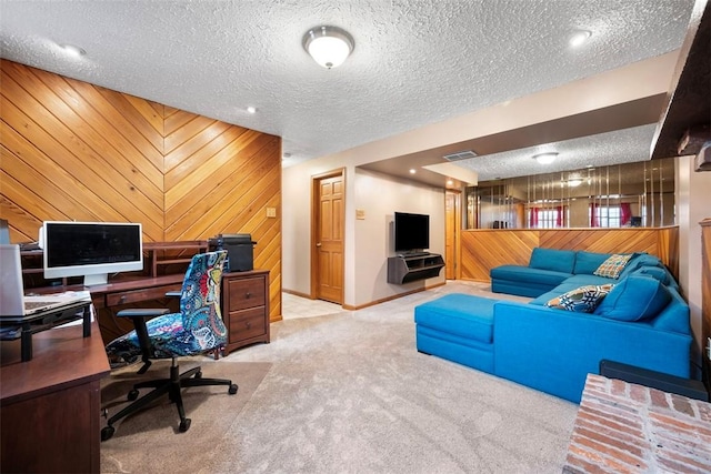 carpeted office with a textured ceiling and wood walls