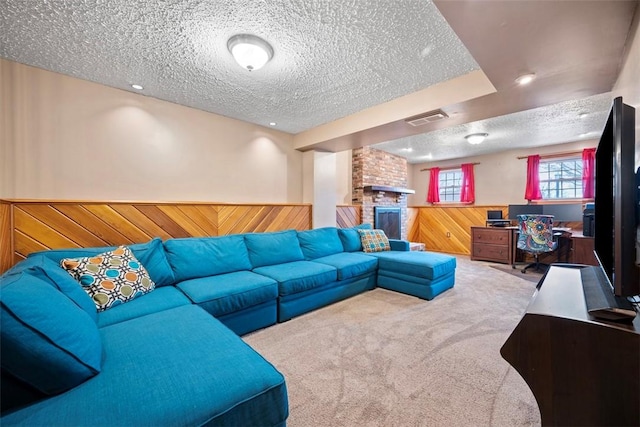 carpeted living room with a fireplace, a textured ceiling, and wood walls