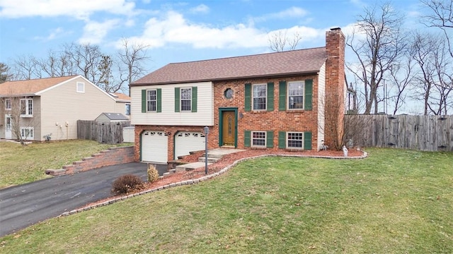 bi-level home featuring a garage and a front yard