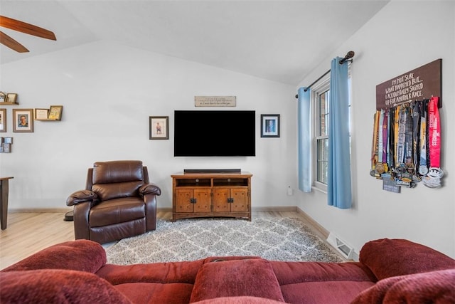 living room featuring ceiling fan, wood-type flooring, and vaulted ceiling