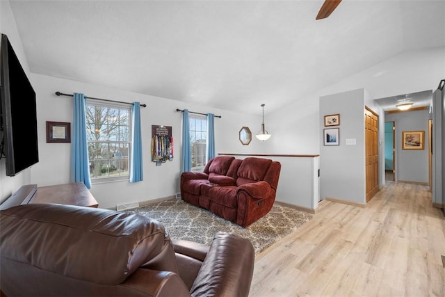 living room featuring lofted ceiling and light hardwood / wood-style flooring