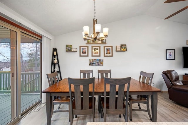 dining area with vaulted ceiling, a chandelier, and light hardwood / wood-style floors