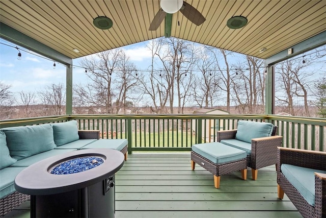 deck with an outdoor living space with a fire pit and ceiling fan