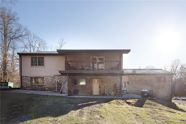 back of house featuring a balcony, a lawn, and a patio area