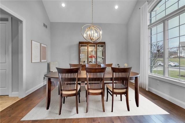 dining space with high vaulted ceiling, dark hardwood / wood-style floors, and a chandelier