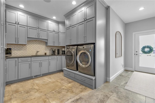 washroom with cabinets, sink, and washing machine and clothes dryer