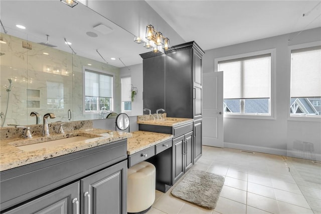 bathroom with tile patterned flooring, vanity, and walk in shower