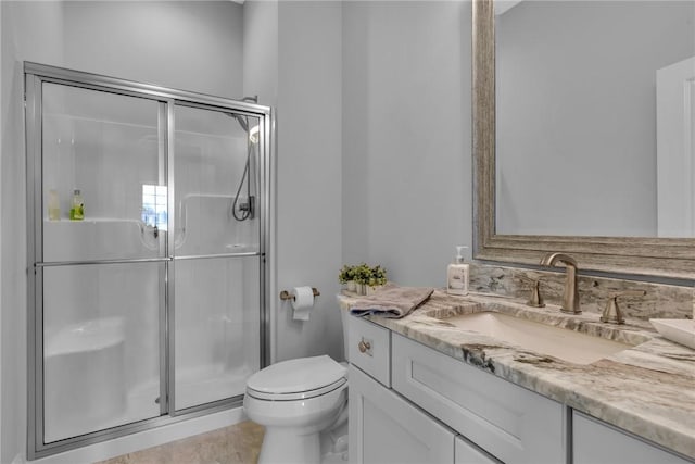 bathroom with an enclosed shower, vanity, and toilet