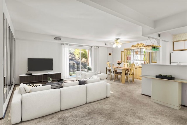 living area featuring carpet floors, visible vents, and a ceiling fan