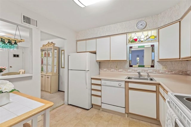 kitchen featuring light countertops, white appliances, a sink, and white cabinetry