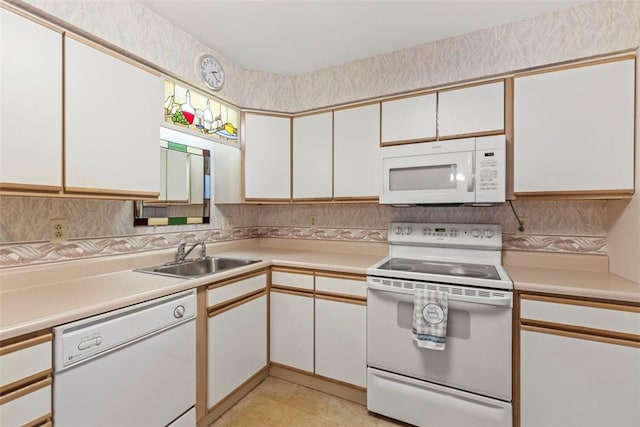 kitchen featuring light countertops, white appliances, a sink, and white cabinetry