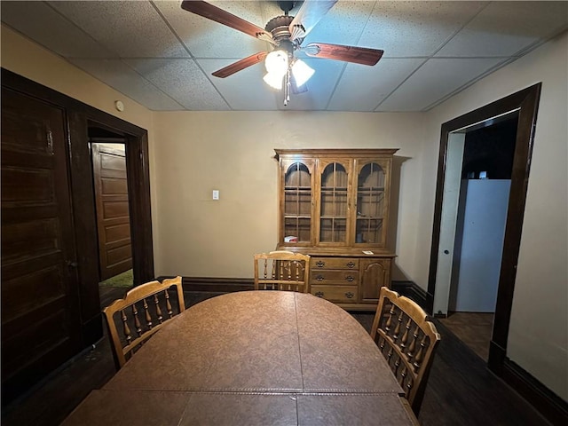 dining room featuring ceiling fan and a drop ceiling