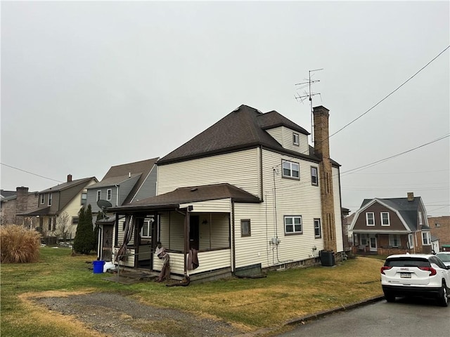 view of property exterior featuring a yard, central AC, and covered porch