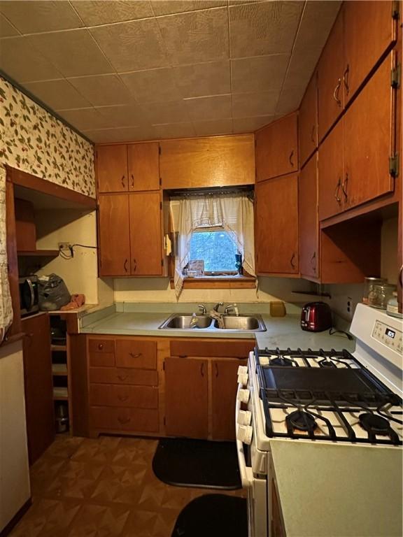 kitchen featuring sink and white range with gas stovetop