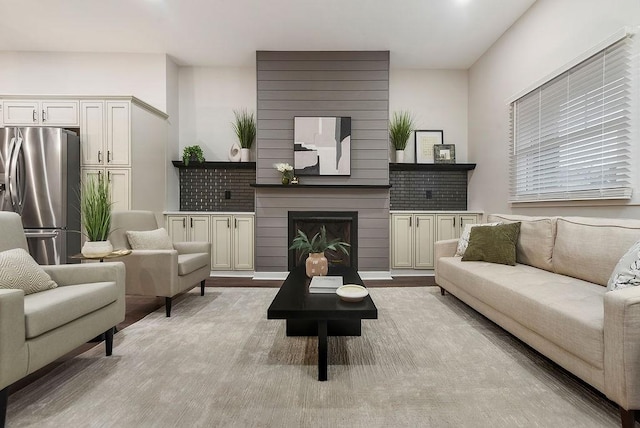 living room featuring light hardwood / wood-style floors and a large fireplace