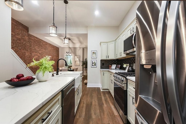 kitchen featuring sink, decorative light fixtures, appliances with stainless steel finishes, dark hardwood / wood-style flooring, and backsplash