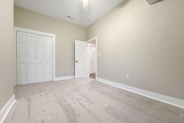 unfurnished bedroom featuring carpet flooring, ceiling fan, and a closet