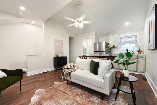 living room featuring dark wood-type flooring, ceiling fan, and vaulted ceiling