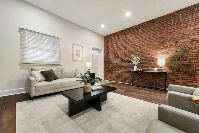 living room with brick wall and hardwood / wood-style floors