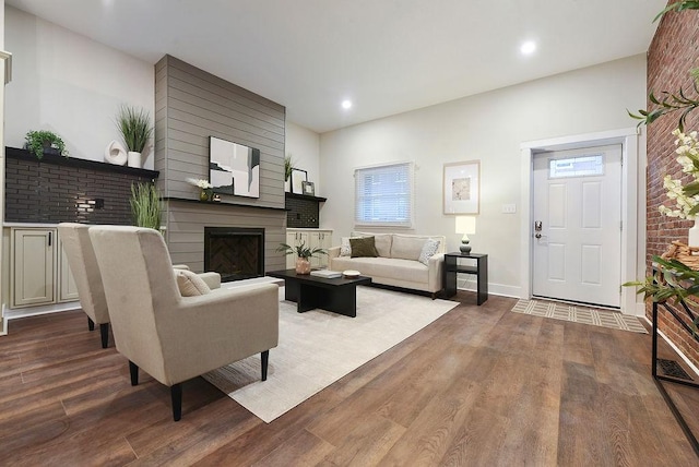 living room featuring hardwood / wood-style flooring and a large fireplace