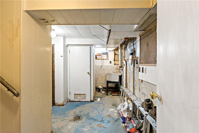 hall featuring concrete flooring and sink