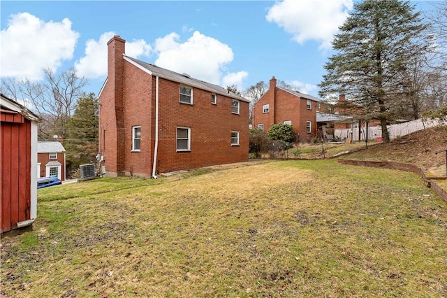 rear view of property with cooling unit and a lawn