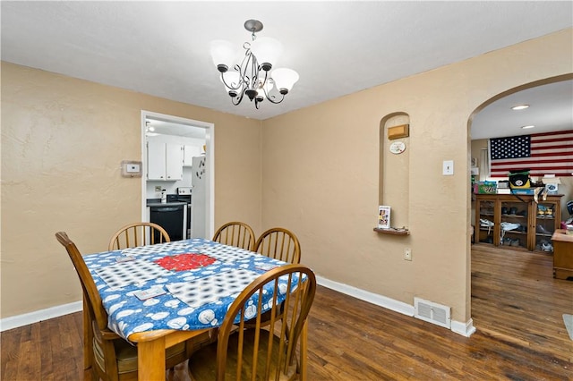 dining room with dark wood-type flooring and a notable chandelier