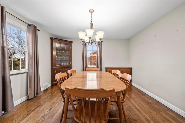 dining room with hardwood / wood-style flooring, plenty of natural light, and a chandelier