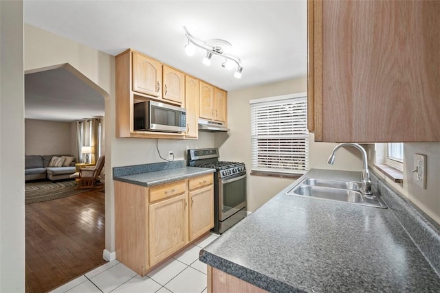 kitchen with appliances with stainless steel finishes, sink, light tile patterned floors, and light brown cabinetry