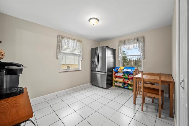 interior space with stainless steel fridge with ice dispenser and light tile patterned floors