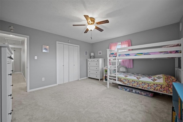 bedroom featuring a textured ceiling, carpet floors, a closet, and ceiling fan