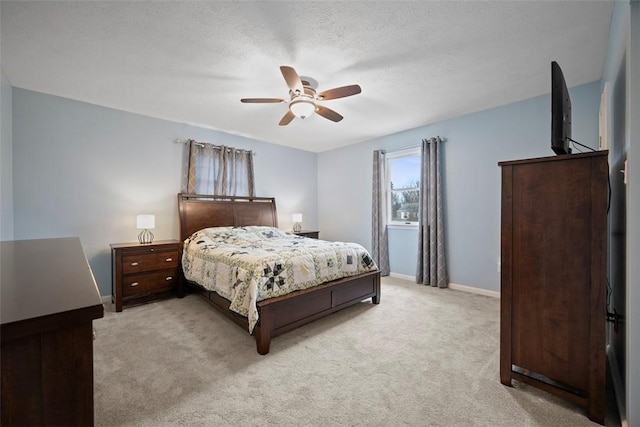 carpeted bedroom featuring ceiling fan and a textured ceiling