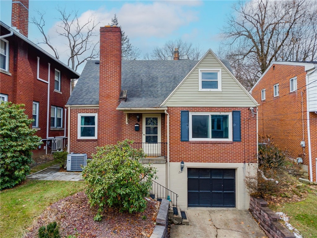 view of front facade with a garage and central AC unit