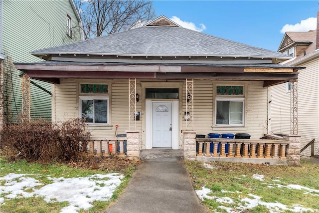 snow covered property entrance with a porch